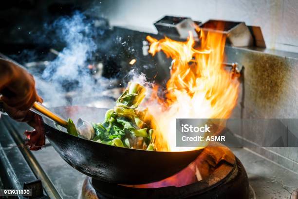 Chefkok In De Keuken Van Het Restaurant Bij Kachel Met Hoge Brandende Vlammen Stockfoto en meer beelden van Kok