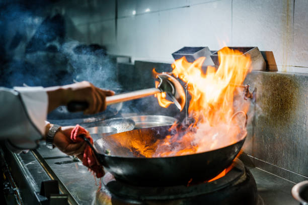 istock Chef in restaurant kitchen at stove with high burning flames 913931836