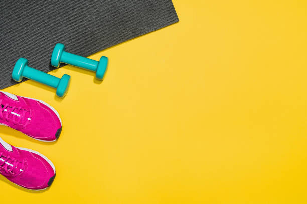 istock Fitness accessories on yellow background mock up, top view 913935774