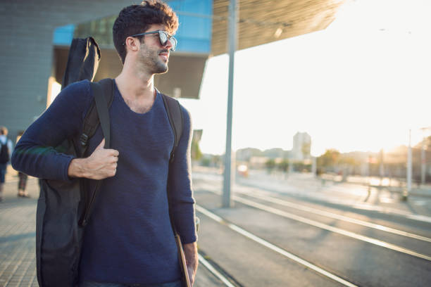 istock Man with guitar on the street 913944394