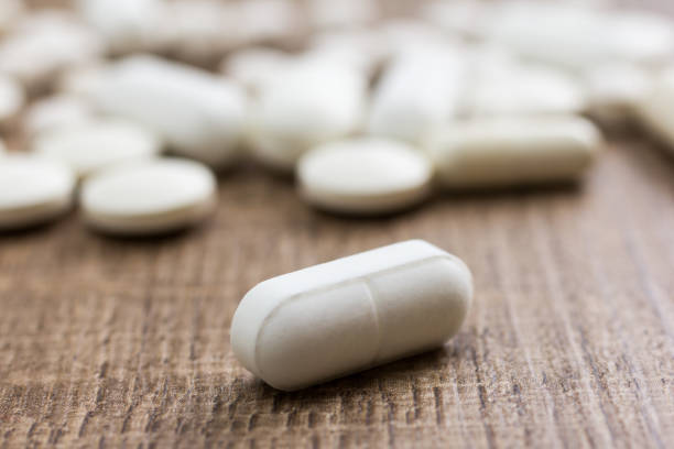 istock Close-Up Of White Pills On Table 913946444