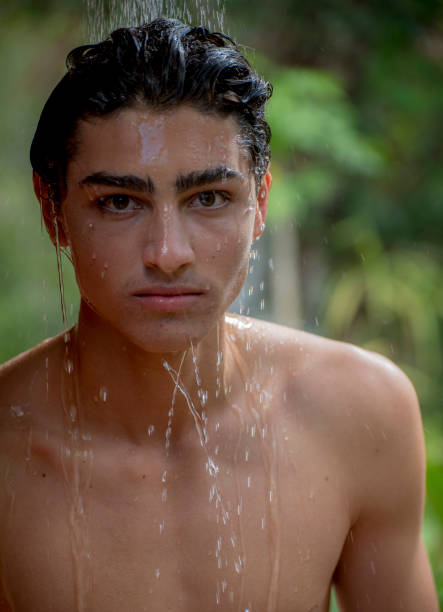 istock Young man cools off in outdoor shower. 913946762