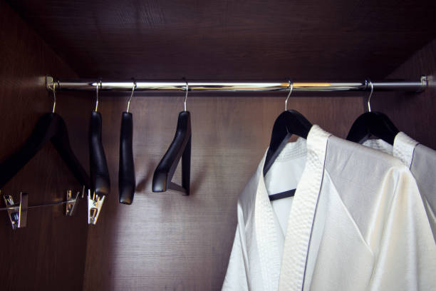 istock White bathrobe with hanger in wardrobe at hotel room 913960550