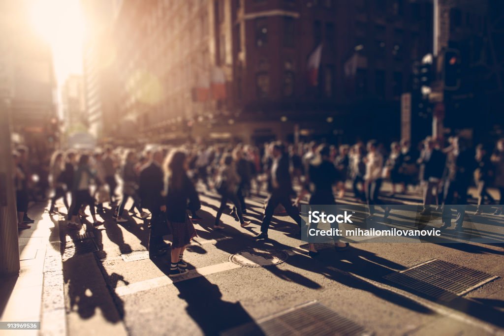 People on the crosswalk Crowd of people walking over the crosswalk at sunset. Sydney, Australia People Stock Photo