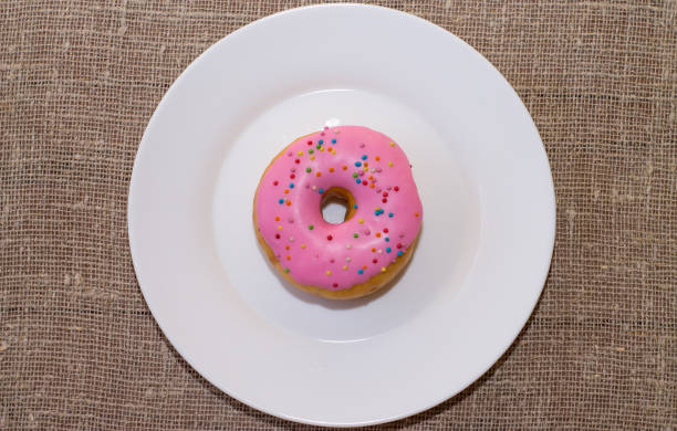 istock Donut with a glaze on a white plate. Colored sweet donut 913975346