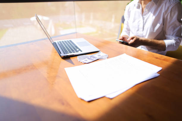 istock Real estate broker talking by smartphone and working with laptop 913976054