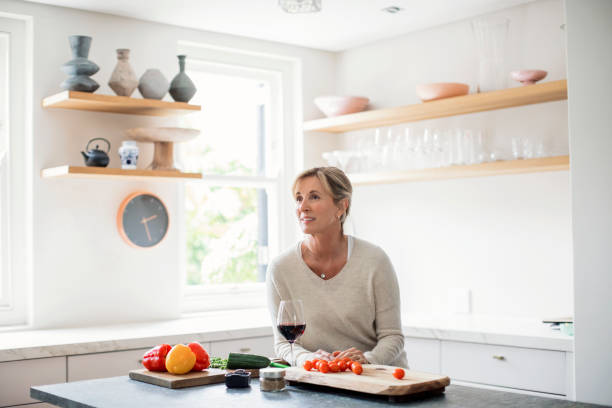 istock Thoughtful mature women sitting at kitchen island 913980350