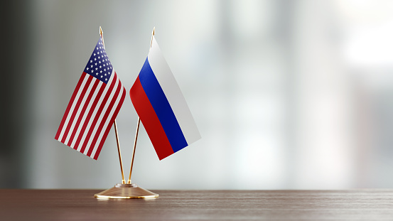 Par de la bandera estadounidense y ruso en un escritorio sobre fondo Defocused photo