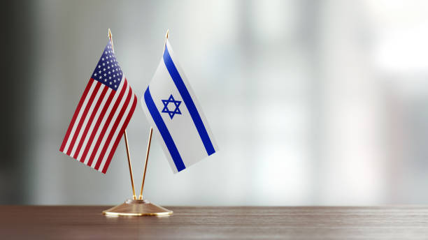 American And Israeli Flag Pair On A Desk Over Defocused Background American and Israeli flag pair on desk over defocused background. Horizontal composition with copy space and selective focus. israeli flag photos stock pictures, royalty-free photos & images
