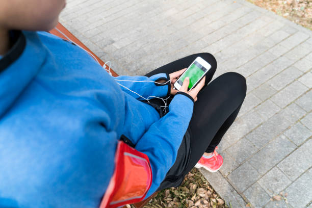 istock Active woman with headphones and cell phone taking a break 913998564