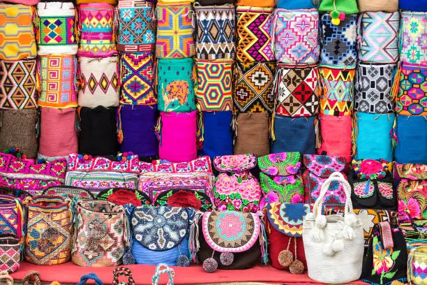 Multicolor knitted backpacks Mochilas Wayúu and bags made by Wayúu natives on the street of the old colonial town in Cartagena, Colombia.
