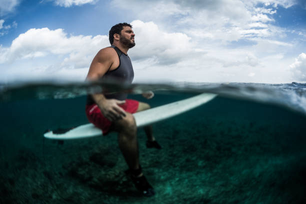 istock Surfer waits the wave on line up with surf board 914011108