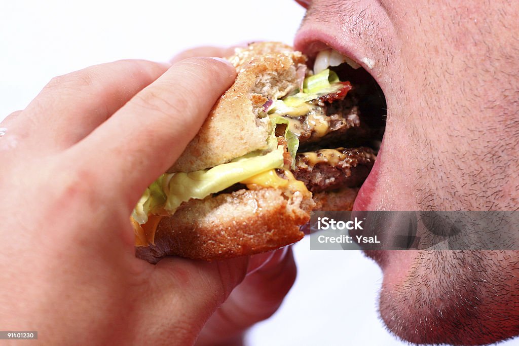 Jovem comendo um suculento hambúrguer - Foto de stock de Comer royalty-free