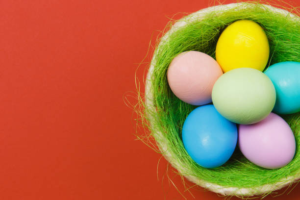 istock Six colorful pastel monophonic painted Easter eggs in basket with green grass isolated on red background. Happy Easter concept. Copy space for advertisement. With place for text. Top view on eggs. 914014072