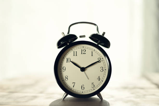 istock Retro alarm clock and books on table 914023684