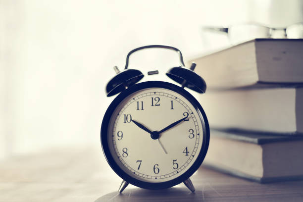 istock Retro alarm clock and books on table 914023694