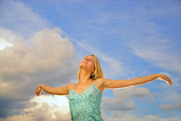 istock Blond girl with arms wide open over blue sky 91402527