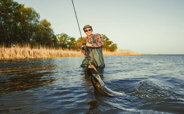 istock The fisherman is holding a fish pike caught on a hook 914030378
