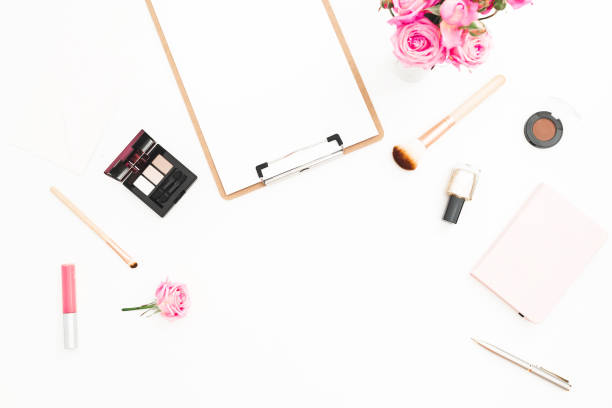 istock Workspace with pastel roses bouquet, cosmetics, diary and clipboard on white background. Top view. Flat lay. Beauty blog with copy space 914041184