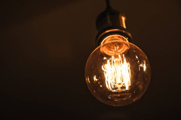 Vintage bulb against black background stock photo