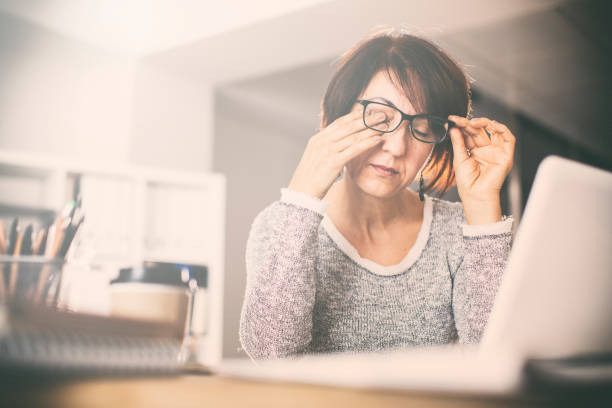 Tired middle age woman rubbing eyes