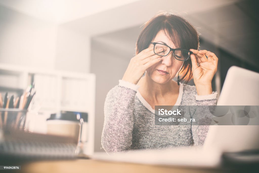 Tired middle age woman rubbing eyes Tired Stock Photo