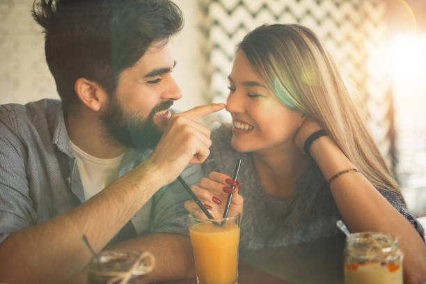 istock Couple sharing orange juice and having fun in cafe. 914046418