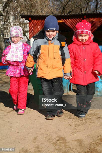 Niño Con Las Niñas En Jardines Foto de stock y más banco de imágenes de Abrigo - Abrigo, Aire libre, Alegre