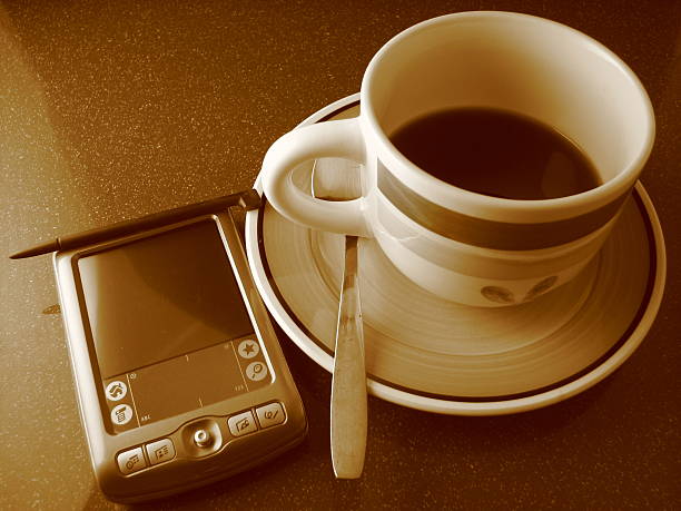 Manhã de café e de PDA - fotografia de stock