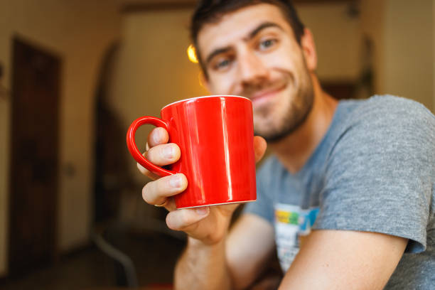 Man holding red cup of coffee in hand, close up
