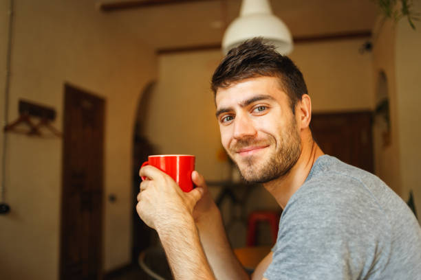 istock Red cup in the hands of a smiling Handsome 914058702