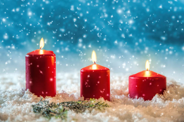 Three candles in the snow greetings card stock photo