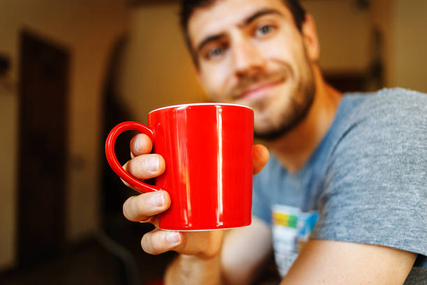 istock Man holding red cup of coffee in hand, close up 914059280
