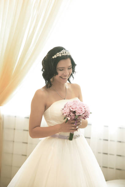 istock smiling happy bride with a bouquet of roses 914062110