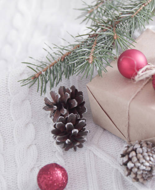 istock gift box and Christmas tree branch and decorations on white 914065760
