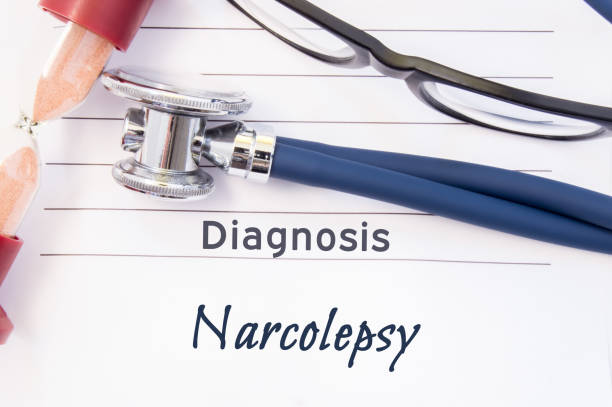 Diagnosis Narcolepsy. Psychiatric diagnosis Narcolepsy is written on paper, on which lay stethoscope and hourglass for measuring time to research. Concept photo for psychiatry or psychology Diagnosis Narcolepsy. Psychiatric diagnosis Narcolepsy is written on paper, on which lay stethoscope and hourglass for measuring time to research. Concept photo for psychiatry or psychology narcolepsy stock pictures, royalty-free photos & images