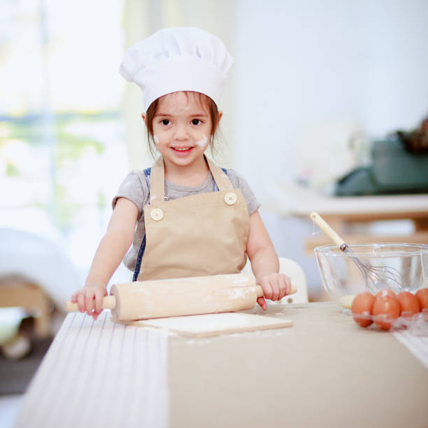 istock Young girl rolling out pastry on kitchen counter 914070434