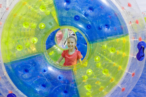 Pretty girl in water-roller Vacation. Inflatable zorbing like fun for teen girl on water in hot summer zorbing stock pictures, royalty-free photos & images