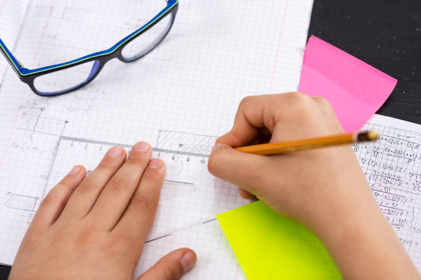 istock Schoolboy Hands with Ruler Drawing on White Paper. Mathematics Concept. 914070676
