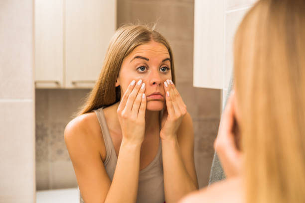 vrouw op zoek oog zakken - moe stockfoto's en -beelden