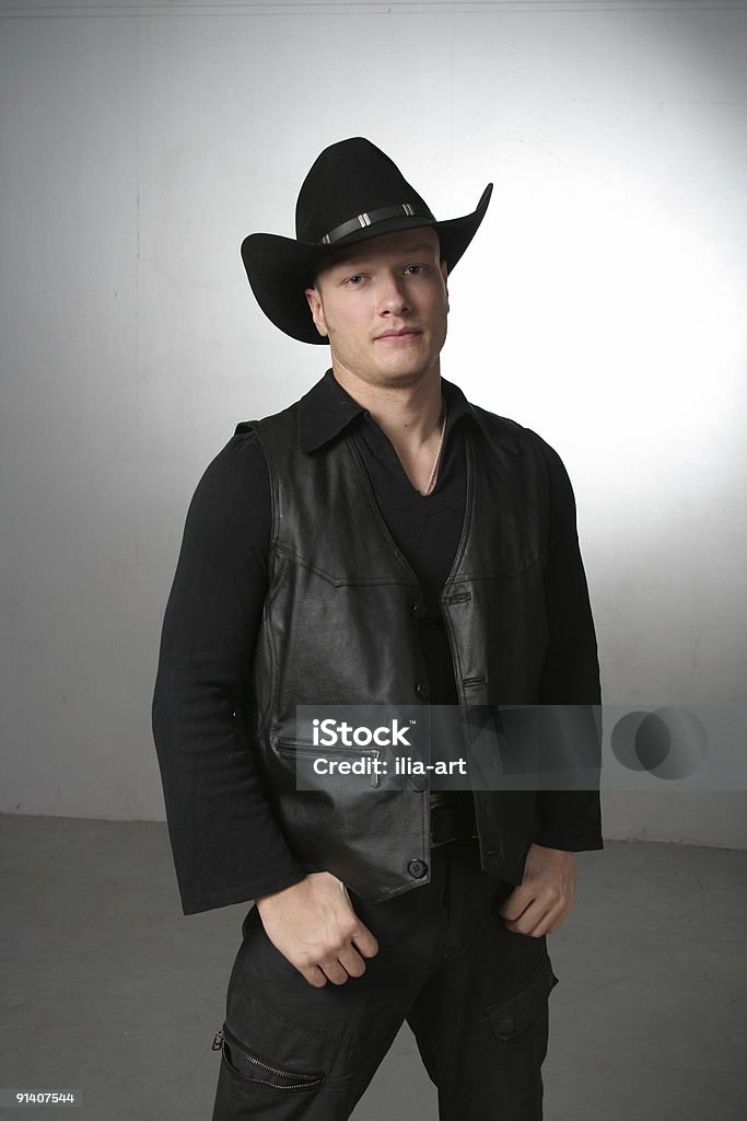 Laziness cowboy Cowboy in a black suit, leather waistcoat and black hat, with a lingering expression. Lazy and just waking up, with a dismissive look. Cowboy Hat Stock Photo