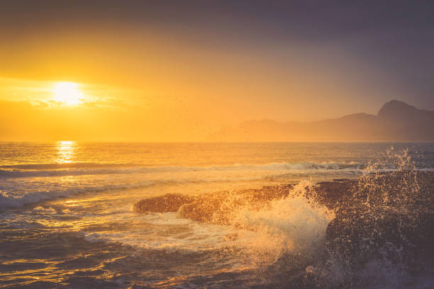 istock Golden sunset over a wavy sea on a mountain coast 914081326