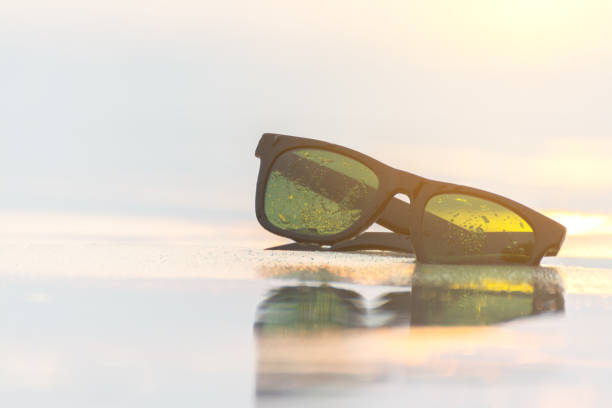 sun glasses on beach and sunset stock photo