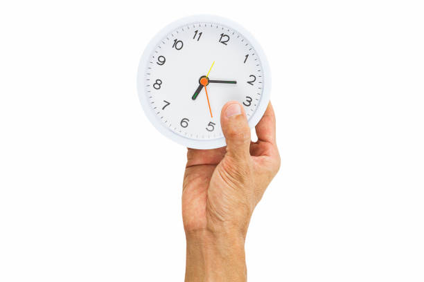 istock Man hand holding alarm clock isolated on white background 914082860