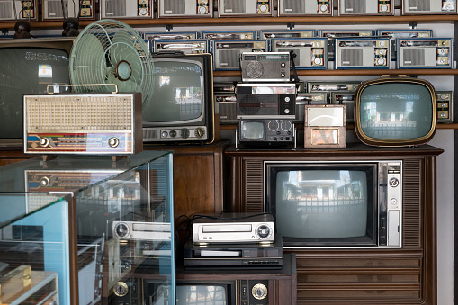 Old vintage different radios, television and electronic in antique store shelves.
