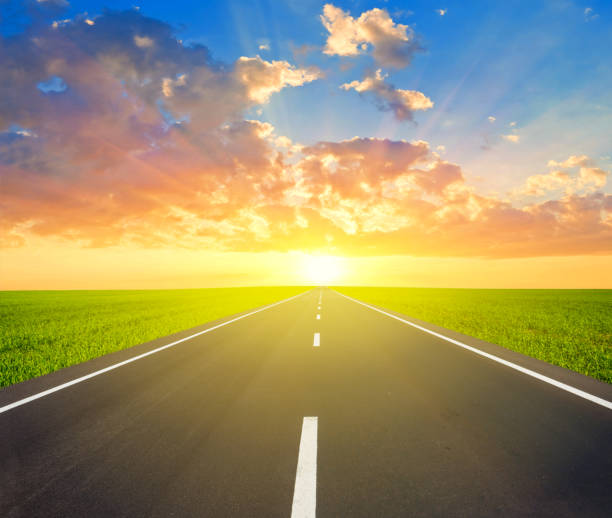 istock asphalt road among a green fields leaving far avay at the sunset 914108570
