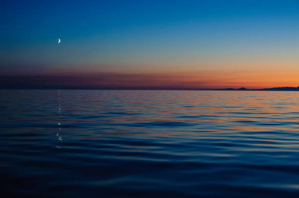 istock Crescent moon over the sea during sunset 914118376