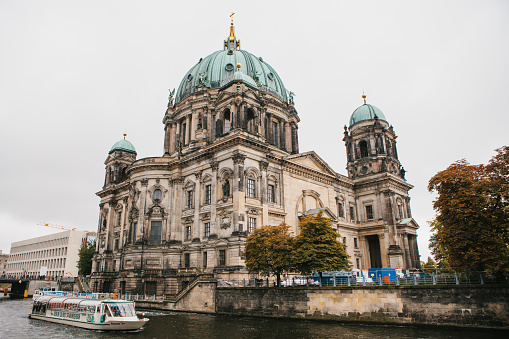 Berlin, October 1, 2017: Berlin Cathedral Berliner dom- beautiful old building with green dome next to the river Spree and tourist boats