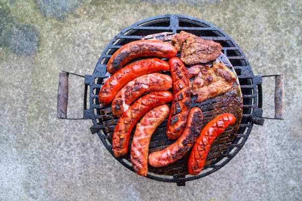 Grilling sausages on barbecue grill.