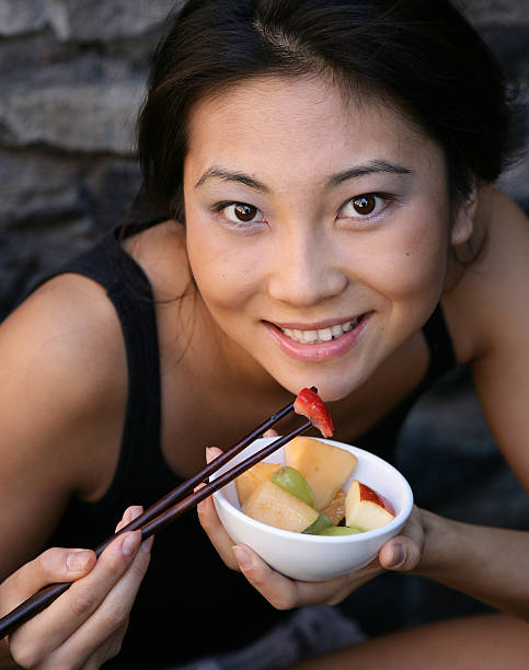アジアの女の子を食べる heathy スナック、 - heathy food ストックフォトと画像
